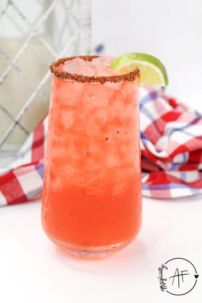 blood orange margarita drink with a lime wedge