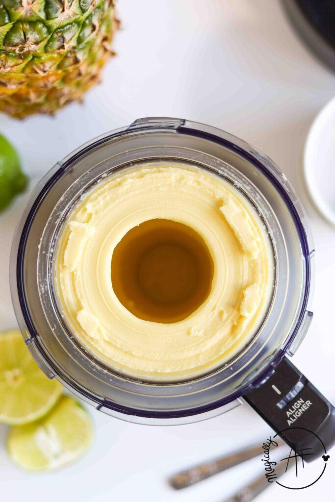 overhead shot of frozen pineapple dole whip in ninja creami container 